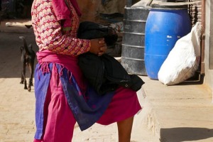 Questa giovane donna nepalese di etnia Newari chiacchera con una sua amica dalla strada nel villaggio di Bungamati, Nepal 2018.