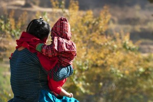 Una giovane mamma Newari tiene in braccio la sua bambina ed entrambe osservano la campagna circostante, dintorni del villaggio di Bungamati, Nepal 2018.