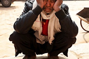 Un anziano Sherpa si riposa a lato della piazza di Durbar Square di Patan (città che è separata da Kathmandu dal fiume Bagmati e considerata un sobborgo della Capitale; i suoi abitanti la chiamano ancora con il vecchio nome sanscrito di Laliptur, "Città della Bellezza", o con il nome newari di "Yala"