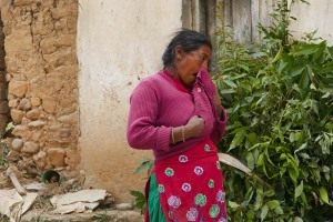 Una delle tre donne Sherpa che dalla campagna hanno portato sulla schiena il foraggio per gli animali, si asciuga il sudore che scende, copioso, dal suo viso dopo lo sforzo. Villaggio di Khokanà, Nepal 2018.