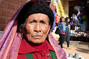 Anziana donna dell'Etnia Tamang indossa un tradizionale orecchino nasale (inserito con un piercing "Septum" che fora la base del setto nasale) che indica il suo alto rango sociale, dintorni di Dirbar Square, Kathmandu, Nepal 2018