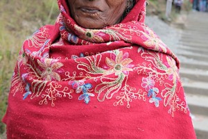 Una donna nepalese di etnia Tamang scende le scale che la porteranno al punto di imbarco del lago Phewa Tal, Pokhara, Nepal 2018