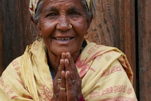 Una anziana donna di origine Tamang mi saluta congiungendo le mani nel gesto tipico di benvenuto nepalese ed indiano del "Namasté": al centro della fronte presenta la "tilaka" (un segno tondo colorato tipico dei seguaci di Shiva che viene denominato anche "Tripundra"), composta da una pasta di "Vibhuti" (cenere consacrata) di colore bianco crema con al centro un cerchio di pasta di sandalo e polvere di curcuma. villaggio di Nagarkot, Nepal 2018.
