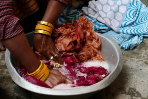 Una donna Tamang lava a mano i suoi vestiti dentro un catino di alluminio: come nel caso delle donne Hindu, qualsiasi lavoro esse svolgano continuano ad indossare i bracciali, gli anelli ed i gioielli con estrema eleganza, Villaggio di Ghatland, Nepal 2018.