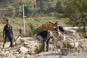 Nel cantiere in prossimità del villaggio di Chapagaon; lavorano anche ragazzi adolescenti di etnia Tamang: in questa immagine caricano pesanti massi sulla carriola; Nepal 2018.