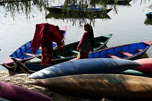 Donne nepalesi di etnia Thakali si accingono ad attraversare il lago di Phewa Tal dalla sponda occidentale a quella orientale su una tradizionale barca costruita artigianalmente: l'eleganza ed il garbo con cui la donna sulla sinistra sistema sul capo il velo rosso mi ha colpito per la comunicazione non verbale che un tale gesto, apparentemente banale, trasmette. L'eleganza è una dote innata e molto rara che questa donna sconosciuta ha rappresentato in modo sublime. Lungolago di Phewa Tal, Pokhara, Nepal 2018.