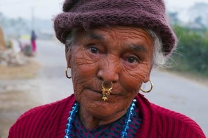 I tharu sono una tribù indigena di lingua indo-ariana diffusa nel Nepal meridionale. Si definiscono "Gente della Foresta" e sono un Popolo di origine mongolica che, per l'87% pratica la religione hinduista, mentre per il 13% quella buddhista, anche se le pratiche animiste ed il culto degli antenati sono ancora molto diffusi. La società è organizzata per Clan ("Dangoura", Kathariya", "Rana") ed ogni Clan ha caratteristiche culturali e tradizioni proprie. Essi si sono adattati perfettamente alle zone forestali da loro abitate (dove si trovano anche zone paludose) e, con il passare del tempo, hanno sviluppato una resistenza naturale ad alcune malattie endemiche come la malaria. I Tharu si crede che siano stati i primi abitanti della Regione del Terai e che discendano direttamente dai Rajput del Rajasthan o dalla dinastia reale dei Sakya, la famiglia del Buddha. Per molto tempo sono stati una minoranza etnica oppressa in Nepal, costretti di fatto in uno stato di servitù denominato "Kamaiya" (lavoratori coatti) da parte dei "Zamindar" (i proprietari terrieri) che fu abolito solamente nel 2008.  Trovano sostentamento tramite le colture di cereali (riso, grano, orzo e mais), oltre alla caccia ed alla pesca. Le proteste, sfociate anche in scontri violenti con diversi morti, da parte dei Tharu e delle altre popolazioni che abitano il Terai, che rivendicano maggiori spazi nelle varie amministrazioni dello Stato (pur essendo una minoranza) ed una maggiore autonomia nelle aree in cui risultano prevalenti, non hanno trovato per ora risposte concrete. Il sistema federale in Nepal è ancora ai primordi e non sarà facile ottenere risposte immediate a queste esigenze pur fondate. Qui una anziana donna Tharu, mi osserva quasi disincantata, come se percepisse l'incertezza nel futuro del suo Popolo. Villaggio di Bacchauli, Nepal 2018.