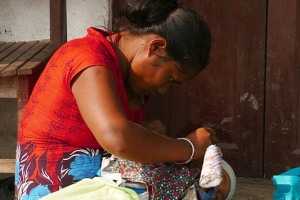 Una giovane mamma Tharu pulisce le orecchie al suo bambino nel cortile della sua abitazione, villaggio di Bacchauli, Chitwan National Park, Nepal 2018.