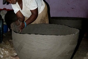 In un piccolo laboratorio artigiano nella Provincia del Limpopo una donna Venda rifinisce a mano un grande vaso in terracotta, Sud Africa 2012