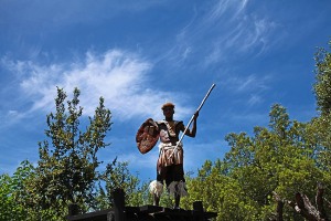 Giovane guerriero Zulu si staglia contro il cielo mentre fa la guardia su una pedana sopraelevata a protezione del Villaggio Aha Lesedi; Sud africa 2012