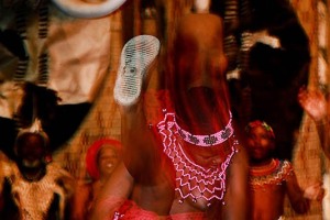Performance di una giovane donna Zulu che in perfetta sincronizzazione con la musica alza alternativamente una gamba sin oltre la testa eseguendo la danza "Ukusina", Villaggio di Shakaland, Provincia del KwaZulu-Natal, sud africa 2012