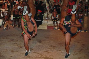 Le giovani donne Zulu con i tipici vestiti impreziositi dalle perline multicolori, muovono passi di danza "Ukusina", alzando alternativamente le gambe in alto sin oltre la propria testa. Danza legata alla cerimonia "Umemulo" che celebra il passaggio della giovane donna Zulu alla maggiore età ed alla possibilità di sposarsi e di procreare. Il rituale prevede anche la macellazione di una mucca che viene offerta a tutti gli abitanti del villaggio che, da parte loro donano denaro e benedizioni alla giovane donna. Villaggio di Shakaland, Provincia del KwaZulu-Natal, Sud africa 2012