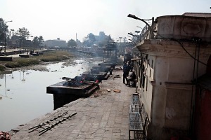 Lungo le sponde del fiume sacro Bagmati, sulle piazzole dei Ghat, si alternano le salme dei defunti che vengono cremati: gli Hindu credono che i diversi momenti della vita corrispondano ad alcuni riti, detti "Samskara" (letteralmente consacrazione o sacramento), e l'insieme del rito funebre hinduista è il "Antyeshti", cioè l'ultimo sacrificio. La religione Hindu insegna che la vita e la morte fanno parte del concetto di Samskara o della rinascita. L'obiettivo finale della maggior parte degli Hindu è liberarsi dal desiderio, evitando così il Samskara per raggiungere il "Moksha" (lo stato trascendente della salvezza). Una volta raggiunto il Moksha, l'anima sarà assorbita nel Brahman, la forza divina e l'ultima realtà.  Pashupsatinath, Kathmandu, Nepal 2018.