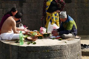 Sui marciapiedi che cingono le sponde del fiume sacro Bagmati si trovano molti santoni che svolgono i loro riti dietro richiesta dei pellegrini: la presunta capacità di attingere ad informazioni da fonti soprannaturali, in genere ritenute inaccessibili per i comuni mortali, mediante rituali religiosi e spirituali, rendono i servigi di questi individui molto ricercati ed apprezzati. Possono essere eseguite interpretazioni di segni, eventi, simboli, presagi o sogni, pratiche di predizione del futuro, cerimonie e pratiche magiche o presunte tali per allontanare la mala sorte. Pashupatinath, Kathmandu, Nepal 2018.