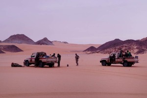 Landscape,la scorta composta da militari Nigerini effettua una sosta tra le dune del Deserto del Ténéré, che, spinte dal vento, si ammassano contro i picchi di roccia ed i massicci montuosi dei monti Tamgak, spesso sovrastandoli in altezza, Regione dell'Air, Niger 2020