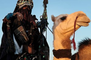 Capovillaggio Tuareg Kel Air indossa una camicia lunga nominata "Akerbas", una tunica larga a maniche corte "Tekatkat", il famoso turbante indaco "Tagelmust" (il velo maschile protegge dalla sabbia, dalle intemperie e dagli spiriti della solitudine che infestano i deserti), impugnando la sua temibile lancia e cavaica il proprio dromedario in attesa della sfilata, Festival dell'Air, Iferouane, Deserto del Ténéré, Regione dell'Air, Niger 2020