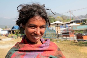 Una donna "Dalit", cioè appartenente agli Intoccabili: in Nepal esistono tra i 3,6 ed i 5 milioni di persone con questo status sociale così discriminante, il che significa che essi comprendono quasi un quinto della popolazione totale. Vi è la credenza diffusa che le persone di casta superiore abbiano avuto origine dalla bocca, dalle braccia o dalle cosce di Dio, mentre i Dalit dai piedi. Il sistema delle caste in Nepal è stato ufficialmente abolito nel lontano 1962, ma tale gerarchia sociale risulta ancora applicata nella vita quotidiana del Paese, d'altrocanto la religione Hinduista impedisce di fatto l'abrogazione delle caste. Le principali caste vengono denominate "Varna" il cui significato è "colori" perchè ogni casta ha il suo colore di appartenenza. Il termine casta in sanscrito si traduce in "nascita". L'atto di nascere pertanto permette di entrare a far parte di una casta. La casta non si sceglie, viene determinata dalla famiglia di appartenenza, dal cognome che si possiede, dal mestiere e dal colore della pelle. In tale contesto i Dalit sono gli unici a lavorare il cuoio (secondo la religione Hinduista la pelle degli animali può essere trattata esclusivamente da individui considerati impuri), cremano i defunti, seppelliscono gli animali morti, ripuliscono le fogne e le latrine. Questi mestieri così degradanti vengono ereditati da padre in figlio e quindi anche le generazioni future restano impure e non possono ambire ad elevare le proprie condizioni di vita. Il sorriso aperto di questa donna sembra voler auspicare ad un improbabile futuro migliore. Lungolago Phewa Tal, Pokhara, Nepal 2018.