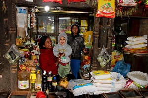 Nel mercato di Asan Tole, una vecchia bottega (presenta ancora le famose colonne in legno intagliate dai mastri artigiani scalpellini, le cui nozioni si tramandano da padre in figlio sin dal XV secolo e che inizialmente rappresentavano prevalentemente Divinità Hindu e solo successivamente introdussero aspetti tipici del Buddhismo), tra le diverse mercanzie, mi offre questo splendido ed inaspettato (quanto gradito) sorriso di un bimbo in braccio alla sua giovane mamma, Kathmandu, Nepal 2018