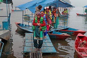 Alcune donne appartenenti a diverse etnie (Thakali, Tamang, Sherpa) scendono di buon mattino dalle barche ("Doonga") provenienti dai diversi villaggi sparsi intorno al lago di Phewa Tal per recarsi al lavoro, Pokhara, Nepal 2018