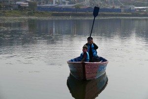 Un papà con il suo bambino dimostra di non essere molto pratico sull'uso del remo nella barca che ha preso in affitto per fare un giro nel lago di Phewa Tal, Pokhara, Nepal 2018.