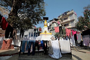 Cheetrapati, un quartiere di Kathmandu dove si concentrano le lavanderie a cielo aperto: uomini e donne, dopo aver lavato a mano i diversi capi di abbigliamento (anche all'interno di antiche cisterne), li stendono sull'erba o su lunghi fili appositamente fissati a pali di legno per farli asciugare, addirittura anche sulle ringhiere che circondano i monumenti. Kathmandu, Nepal 2018