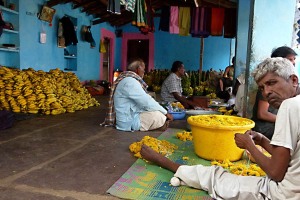 Nel mercato di Saundatti si confezionano a mano ghirlande di fiori da offrire alla Dea Yallamma. Regione del Karnataka, India 2015.