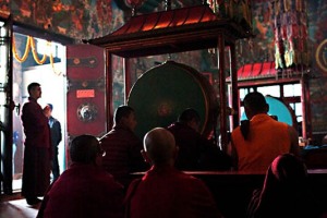Monaci novizi, insieme ai monaci lama (monaci buddhisti di alto rango), assistono alla cerimonia Chakra Darma nella sala di preghiera principale del Guru Lhakhang Monastery, preziosamente decorata con dipinti murali raffiguranti le quattro divinità guardiane che scacciano l'ignoranza e la Ruota della Vita, un diagramma estremamente complesso che raffigura l'attitudine del Buddha a comprendere come gli esseri umani siano legati dal desiderio ad un infinito ciclo di vita, morte e rinascita. L'atmosfera che aleggia durante la cerimonia è di grande suggestione ed intensità. Vicinanze dello Stupa Bodhnath, Kathmandu, Nepal 2018