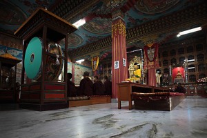 L'interno della Sala preghiere dei monaci Buddhisti nel Jangchub Choeling Monastery di Pokhara: in primo piano i grandi tamburi da cerimonia, gli affreschi che decorano il soffitto e le pareti, le statue che raffigurano il Buddha posizionate all'interno di bacheche in vetro. Nepal 2018.