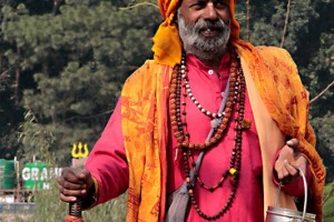 Un Sadhu ("in sanscrito "Sadhus", persona buona) con il suo bastone rituale e la gavetta per la raccolta del cibo offerto dai pellegrini (i santoni o Baba indiani, sono considerati come saggi che scelgono di abbandonare le illusioni della vita materiale dedicandola alla ricerca di una elevazione spirituale. Per fare ciò troncano i legami con la famiglia di origine, abbandonano tutti i loro averi vivendo di elemosina e dei doni ricevuti dai devoti. Si attengono a cinque voti fondamentali e irrinunciabili: "Ahimsa" (la non violenza), "Satya" (la verità), "Asteya" (impegno a non rubare), "Brahmacharya" (astinenza dal sesso e dai piaceri sensuali), "Aparigraha" (impegno a non possedere nulla). Trascorrono gran parte del loro tempo alla ricerca dell'illuminazione recitando i sacri mantra, praticando yoga ed il controllo del respiro). Lungo le sponde del lago Phewa Tal di Pokhara, Nepal 2018