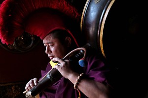 Un monaco tibetano, addetto a suonare il grande tamburo da preghiera utilizzato durante le più importanti cerimonie religiose, si concentra poco prima di iniziare la sua esibizione musicale, Guru Lhakhang Monastery di Bodhnath, Nepal 2018