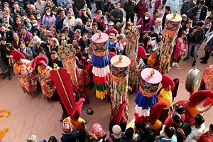 Nel piazzale esterno al Guru Lhakhang Monastery, si svolge una parte della cerimonia Chakra Darma con l'esposizione degli 8 simboli di Buon Auspicio, denominati anche Preziosi Simboli, tra i più antichi della cultura tibetana: il parasole (in sanscrito "Chattra") è il simbolo della dignità regale e rappresenta il potere spirituale; i pesci d'oro (in sanscrito "Suvarnamatsya") sono un simbolo religioso antichissimo, in India rappresentavano i fiumi sacri del Gange e dello Yamuna con dei pesci, essi simboleggiano il superamento di qualsiasi ostacolo, la vittoria su tutte le sofferenze ed il raggiungimento della liberazione; il Vaso della ricchezza (in sanscrito "Kalasa") è un recipiente tondo con il collo ritorto e stretto che poi si allarga formando un bordo decorato.L'apertura del vaso è sigillata con un grande gioiello indicando chiaramente che si tratta di un vaso che racchiude appunto la ricchezza.Simboleggia la realizzazione spirituale, la perfezione del Dharma, la longevità e la prosperità; il Fiore di Loto (in sanscrito "Padme") simboleggia la purezza in quanto, pur affondando le sue radici nel fango, produce bellissimi fiori sopra il pelo dell'acqua. Rappresenta pertanto la purezza in particolar modo quella spirituale; la Conchiglia (in sanscrito "Sankha") utilizzata fin dall'antichità come strumento rituale ed anche musicale rappresenta la gloria dell'insegnamento del Dharma che si diffonde in ogni direzione come il suono della conchiglia e simboleggia l'abbandono dell'ignoranza; il Nodo Infinito (in sanscrito "Srivatsa") è costituito da un nodo chiuso composto da linee intrecciate ad angolo retto e rappresenta l'infinita conoscenza e saggezza del Buddha e l'eternità dei suoi insegnamenti; il Vessillo di Vittoria (in sanscrito "Dhvaja") è realizzato generalmente in legno e tessuto ma a volte anche in metallo. Consiste in uno stretto cilindro di tessuto con tre o più strisce di seta adornato con nastri di cinque colori e rappresenta la vittoria degli insegnamenti buddhisti, la vittoria della conoscenza sull'ignoranza e sulla paura, la vittoria del Dharma contro tutti gli ostacoli ed il raggiungimento della felicità; la Ruota del Dharma (in sanscrito "Chakra") si compone di un mozzo centrale, di 8 o più raggi e di un cerchione esterno. Il mozzo rappresenta l'addestramento alla disciplina morale che rende stabile la mente, i raggi rappresentano la comprensione della vacuità di tutti i fenomeni che permette di eliminare alla radice la nostra ignoranza, il cerchione esterno, infine, identifica la concentrazione che consente di tenere salda la pratica della dottrina buddhista. Simboleggia l'insegnamento buddhista nella sua globalità, il Dharma abbraccia tutte le cose, non ha nè inizio nè fine, è in movimento ed immobile nello stesso tempo. Nepal 2018