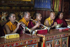 Il concerto continua nell'interno del Guru Lhakhang Monastery di Bodhnath, dove, seduti nelle logge preziosamente decorate della Sala di preghiere, i monaci tibetani suonano i loto strumenti, Nepal 2018