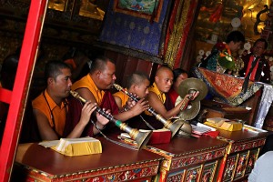 Nel Guru Lhakhang Monastery, durante la Cerimonia Chakra Dharma, alcuni monaci buddhisti suonano le trombe "Jialing" (uno strumento a fiato tradizionale tibetano simile ad un "Oboe" ma con un lungo corpo in legno particolarmente duro e con la parte terminale in metallo sbalzato) insieme ai cimbali a dita, uno strumento musicale a percussione composto da una coppia di piatti metallici in ottone, accompagnati dal canto tantrico corale "Gyer" ; queste pratiche sonore sono considerate quali offerte musicali nelle cerimonie spirituali durante la "Puja" (preghiera rituale): gli strumenti utilizzati sono un mezzo per entrare in contatto con l'energia presente in natura e con le Divinità, Bodhnath, Nepal 2018