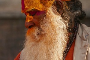 Anche un Sadhu, pur essendo considerato un santo "deificato", oltre che un uomo buono ed onesto, schiaccia un pisolino tra le decine di piccoli santuari dedicati a Shiva che sono disseminati nel grande complesso religioso di Pashupatinath. Kathmandu, Nepal 2018.