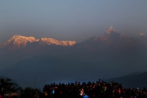 Lo spettacolo del sole che lentamente sorge sullo stupefacente panorama della catena montuosa dell'Annapurna, spinge un'orda di turisti (prevalentemente cinesi) chiassosi e maleducati ad accalcarsi sul punto panoramico del villaggio Newari di Dhulikhel, Nepal 2018.