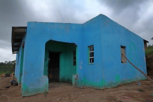 Una delle nuove abitazioni che, inesorabilmente, stanno sostituendo le capanne in argilla con il tetto in paglia: queste costruzioni sono in mattoni con il tetto in lamiera, presentano alcune finestre ed hanno una porta di ingresso, villaggio di Ludzidzini, eSwatini (ex Swaziland) 2012.