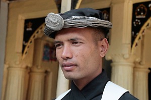 All'ingresso del Palazzo Reale di Patan, sul lato est di Durbar Square, un giovane ragazzo nepalese con i tipici costumi tradizionali, svolge servizio di vigilanza, Nepal 2018