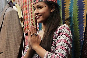 Lungo Tersapati Road nella città vecchia di Pokhara, all'interno del Bazaar Nuovo, vi sono innumerevoli negozi di stoffe: questa giovane ragazza nepalese saluta l'ingresso di alcuni clienti con il tradizionale "Namastè" (mi inchino alla Divinità che risiede in te), Nepal 2018