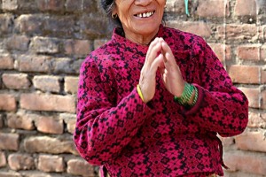 Una anziana donna di etnia Tamang mi sorride (il sorriso mite e pacato evidenzia la serenità del suo animo) giungendo le mani nel tipico saluto nepalese "Namastè" (mi inchino alla Divinità che risiede in te), Villaggio di Budhanilkantha, Nepal 2018