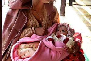 Una giovane e affascinante mamma nepalese culla la sua bambina: la condizione femminile in Nepal è particolarmente pesante. Il tasso di mortalità è molto più alto rispetto a quello maschile, il tasso di alfabetizzazione è di gran lunga più basso. Le donne lavorano di più e hanno diritto ad una paga inferiore. Possono migliorare la loro posizione nella società soltanto a patto di procreare un figlio maschio per il marito. La società nepalese risulta essere fortemente patriarcale: solitamente le donne sono le ultime a poter mangiare e le prime a dover abbandonare la scuola in caso di difficoltà economiche della famiglia. Sino alla prima mestruazione le ragazze sono considerate "intoccabili" e successivamente, in alcune comunità, possono essere isolate ed allontanate durante il ciclo perchè considerate "impure". villaggio di Bandipur, Nepal 2018