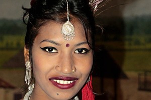 Elegante ed aggraziata ballerina di etnia Tharu che indossa i tradizionali abiti della festa ed in particolare la piuma di pavone tra i lunghi capelli raccolti in uno chignon, si concede al mio obiettivo. Villaggio di Sauraha, Chitwan National Park, Nepal 2018