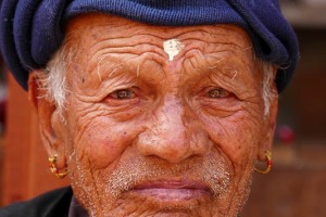 Un intenso ritratto di un uomo Newari: all'età di 77 anni, 7 mesi, 7 settimane, 7 giorni e 7 ore gli uomini e le donne di questa etnia vengono onorati come "Divinità anziane" tramite una cerimonia rituale denominata "Janku" e per l'occasione indossano un paio di particolari orecchini di colore oro con una decorazione rossa. Questo rituale viene celebrato più volte durante la vita dei Newari: ad 88 anni, 8 mesi ed 8 giorni, a 99 anni, 9 mesi e 9 giorni, a 105 anni, 8 mesi ed 8 giorni. Si crede che, il raggiungimento di queste età anagrafiche, coincida  con particolari momenti in cui la persona potrebbe incorrere in problemi di salute ma, proprio tramite queste cerimonie si venerano alcune Divinità (come il Sole e la Luna) per allontanare possibili malattie ed augurare lunga vita. Villaggio di Khokanà, Nepal 2018.