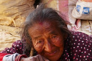 Una anziana donna Newari siede all'esterno della sua bottega dove vende cereali, villaggio di Bungamati, Nepal 2018.