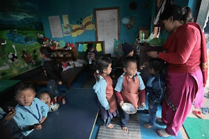 Nella Shree Bal Bikosh Basic School di Kathmandu i bambini hanno quasi terminato la pausa del pranzo sotto l'occhio vigile della loro maestra, Nepal 2018