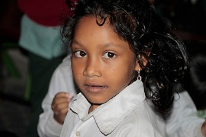 Nell'aula gremita di bambini che giocano della Shree Bal Bikosh Basic School, lo sguardo espressivo e vivace di questa bambina spicca su tutti, Kathmandu, Nepal 2018