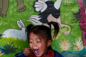 Una bimba nepalese di etnia Newari sembra gradire molto il riso che ha ricevuto per pranzo, Shree Bal Bikosh Basic School, nel quartiere Cheetrapati di Kathmandu, Nepal 2018.