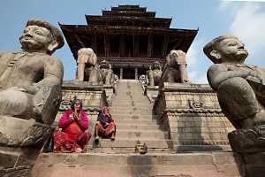 Il Tempio più antico del Nepal: lo splendido Krishna Mandir costruito nel 1637 dal re Siddhinarsingh con pietre intagliate a mano. Due donne nepalesi pregano sulla gradinata, Patan, Nepal 2018