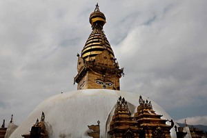 Il Tempio buddhista di Swayambhunath; posto sulla sommità di una collina in posizione dominante sulla città di Kathmandu; rappresenta un esempio affascinante e forse unico di fusione ed integrazione dell'iconografia buddhista ed hindu: lo scintillante Stupa bianco; sormontato da una guglia dorata sulla quale sono disegnati gli occhi del Buddha che dirigono lo sguardo nei quattro punti cardinali (sono conosciuti come "occhi della saggezza" che hanno la capacità di vedere tutto). Tra gli occhi del Buddha; dove dovrebbe essere rappresentato il naso; c'è un simbolo molto particolare; una sorta di riccio che assomiglia ad un punto interrogativo. Questo corrisponde al carattere nepalese che indica il numero 1 : esso rappresenta l'unità di tutte le cose; nonchè il modo di raggiungere l'illuminazione attraverso gli insegnamenti del Buddha. Sopra di quest'ultimo si trova il terzo occhio del Buddha; simbolo del risveglio spirituale ed indica la saggezza del Buddha. Esiste una leggenda: si racconta che un tempo la valle di Kathmandu fosse un lago (lo confermano prove geologiche) dalle cui acque emerse spontaneamente la collina dove oggi sorge il complesso di Swayambhunath; da questa leggenda è derivato il nome "swayambhu" che significa appunto "sorto da sè". Da notare che anche i macachi sono vicini agli occhi del Buddha; equamente distribuiti sulla cupola bianca. Nepal 2018.