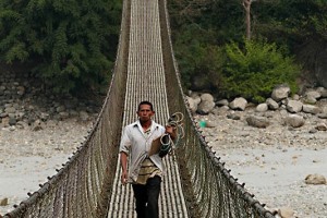 Uno dei rari ponti sospesi tra una sponda e l'altra del fiume Narayani, vero gioiello architettonico nepalese: lo attraversa un contadino senza essere costretto a guadare il fiume, Nepal 2018.