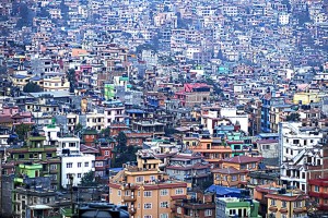Dal Tempio buddhista di Swayambhunath, posto su una collina che domina la città di Kathmandu, l'enorme capitale nepalese si presenta nel suo vasto e caleidoscopico panorama urbano: un sovrapporsi di edifici costruiti negli anni '90, subito dopo il termine della rivolta maoista, sorti talmente rapidamente da mettere in difficoltà ancora oggi le infrastrutture che dovrebbero gestire le esigenze della popolazione. Nepal 2018.